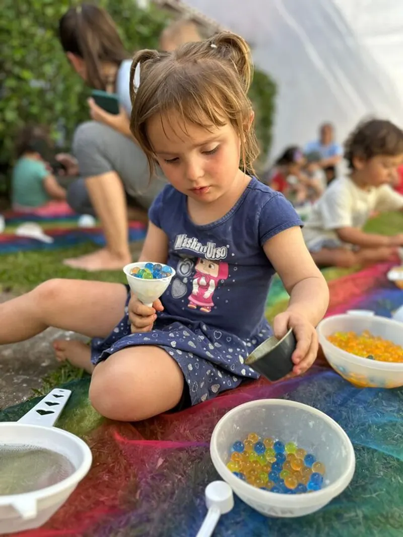 criança pequena explorando materiais ao ar livre, em movimento livre