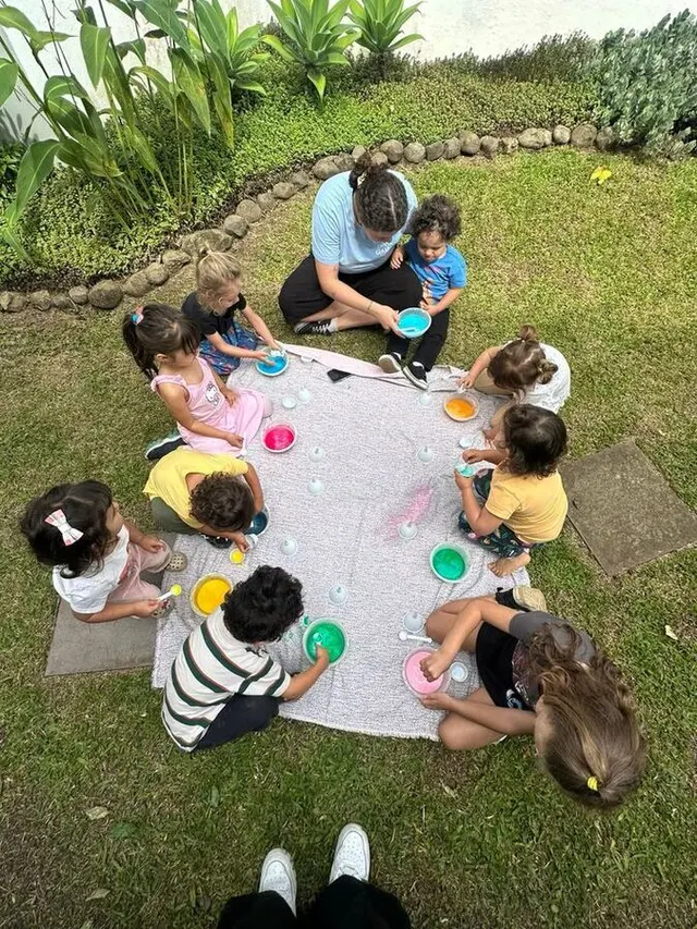 Crianças brincando em roda no quintal do Espaço Santa Gianna em Curitiba