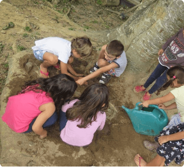 Crianças brincando em grupo e desenvolvendo habilidades sociais no quintal brincante Santa Gianna em Curitiba