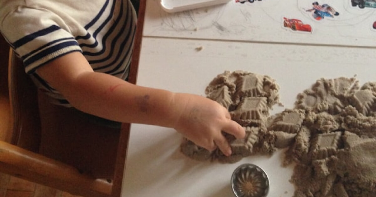 criança brincando com argila em uma mesa